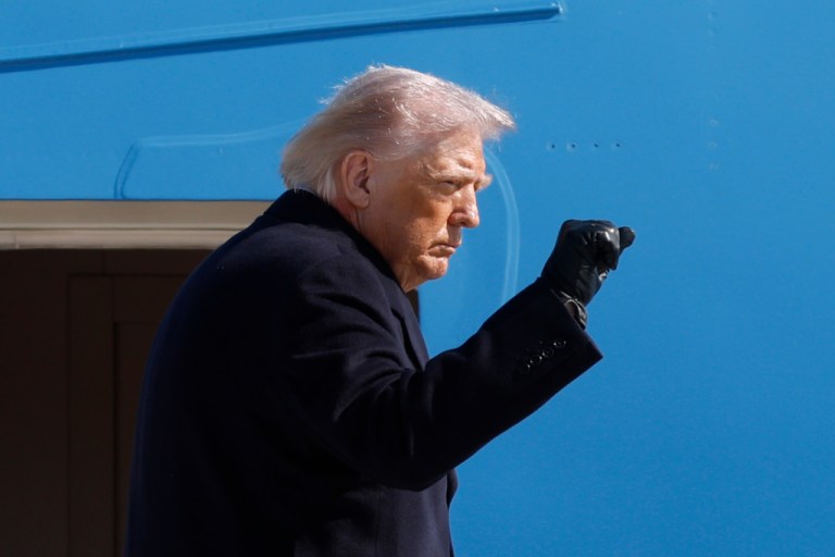 President Donald Trump gestures from the stairs of Air Force One
