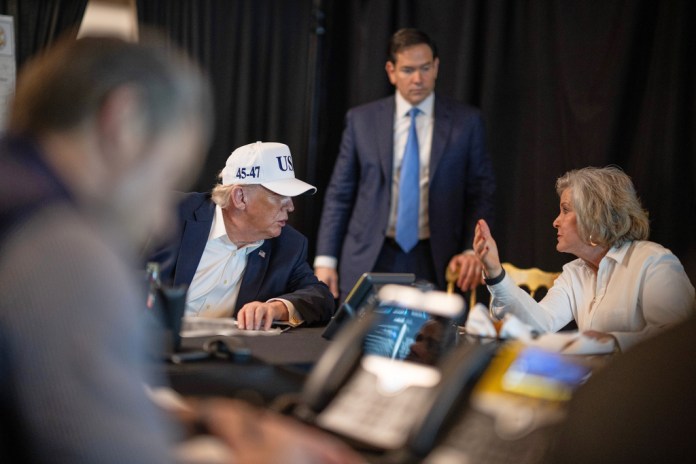 This photo provided by the White House which has been partially blurred, shows President Donald Trump talking with White House chief of staff Susie Wiles as Secretary of State Marco Rubio listens at Mar-a-Lago in Palm Beach, Fla., during Operation Epic Fury on Saturday, Feb. 28, 2026