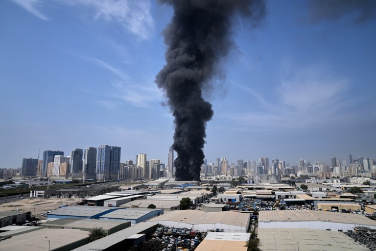 A black plume of smoke rises from a warehouse at the industrial area of Sharjah City in the United Arab Emirates.