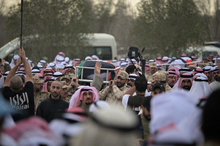 Kuwaitis carry the bodies of two soldiers killed by Iranian strikes.
