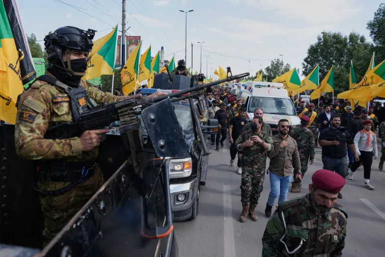 Members from the Popular Mobilization Forces attend the funeral of fighters from Kataib Hezbollah, who were killed in a U.S. airstrike near Baghdad, Iraq, in March 2026.
