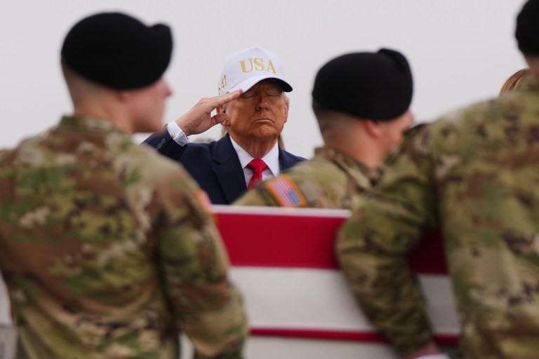 President Donald Trump salutes as an Army carry team moves the flag-draped transfer case