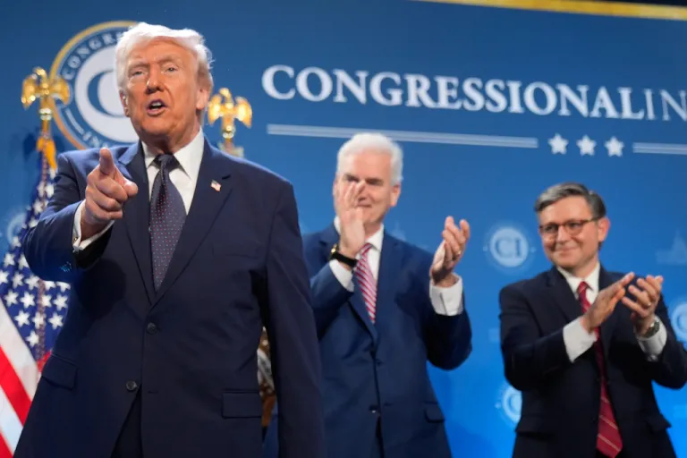 President Donald Trump gestures as Rep. Tom Emmer, R-Minn., and House Speaker Mike Johnson of La., applaud at the Republican Members Issues Conference.