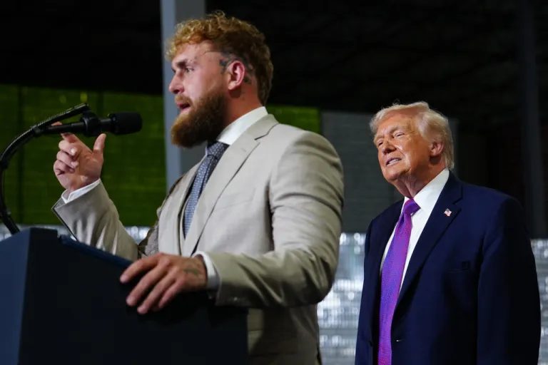 President Donald Trump listens as Jake Paul speaks.