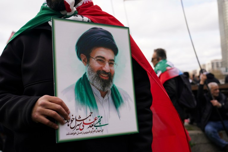 A demonstrator holds a portrait of the Ayatollah Mojtaba Khamenei.