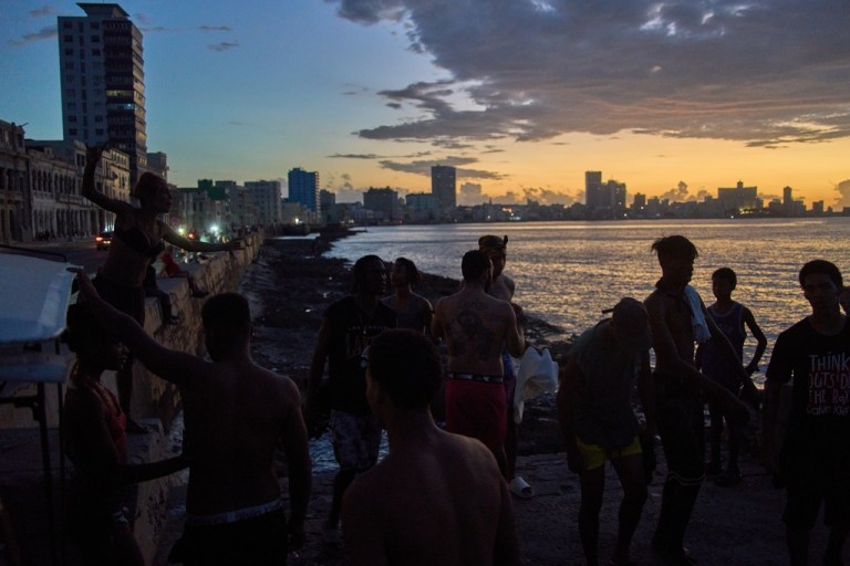 People watch the sunset from the Malecón during a blackout in Havana.