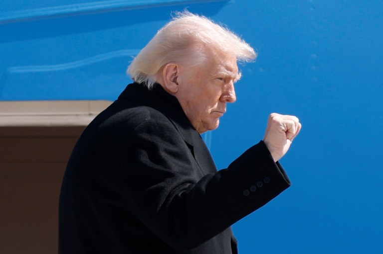 President Donald Trump gestures as he boards Air Force One
