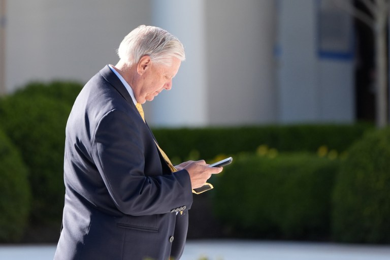 Sen. Lindsey Graham, R-S.C., looks at his phone in the Rose Garden