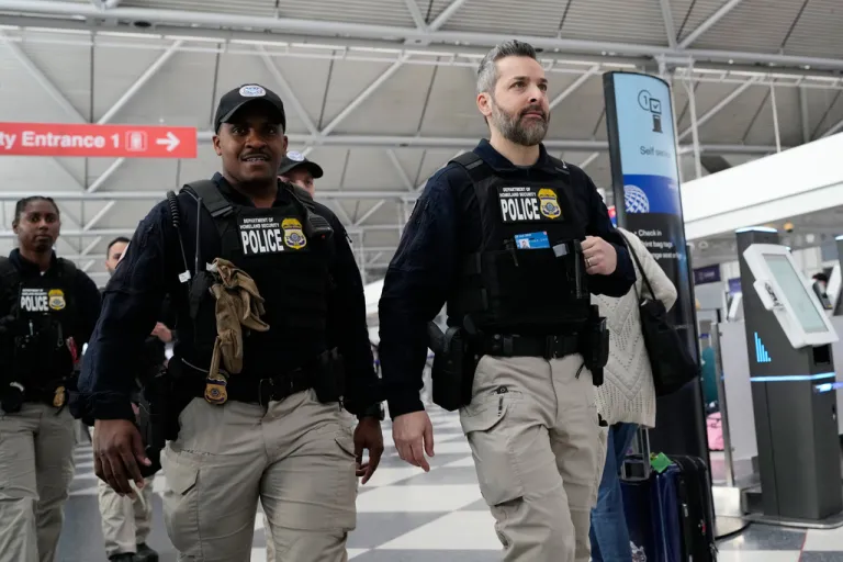 U.S. Immigration and Customs Enforcement (ICE) agents walk though the terminal 1 at O'Hare International Airport in Chicago, Tuesday, March 24, 2026. (AP Photo/Nam Y. Huh)