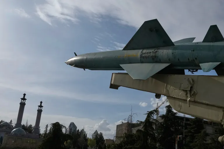 A missile is displayed in a permanent exhibition at a recreational area as minarets of a mosque are seen at rear, in northern Tehran