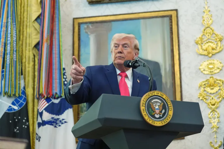 President Donald Trump speaks with reporters during the swearing-in for Homeland Security Secretary Markwayne Mullin in the Oval Office.