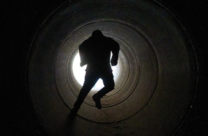 A boy runs inside a cement pipe serving as a bomb shelter while air raid sirens warn of incoming Iranian missiles in Michmoret, Israel, March 10, 2026. (Ariel Schalit/AP)