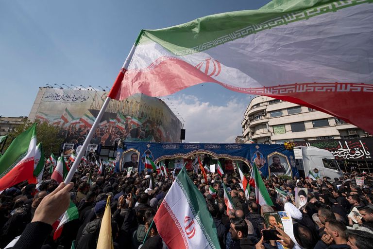 A truck carries the coffins of Ali Larijani, Secretary of the Supreme National Security Council, and Gholamreza Soleimani, commander of the Paramilitary Basij Forces, during a funeral for Larijani, Soleimani, and the crew of the sunken IRIS Dena warship in Tehran, Iran, on March 18, 2026. The Iranian Navy frigate IRIS Dena was torpedoed and sunk by the United States Navy's Los Angeles-class submarine USS Charlotte in the Indian Ocean during the 2026 Iran conflict. (Photo by Morteza Nikoubazl/NurPhoto via Getty Images)