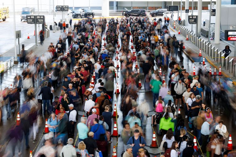 Travelers wait in line at a Transportation Security Administration checkpoint.