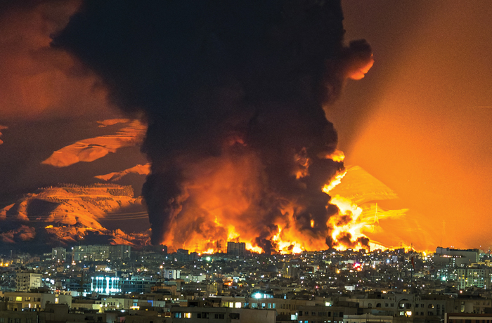 Smoke and flames rise at the site of U.S. and Israeli airstrikes on an oil depot in Tehran on March 7. (Sasan/Middle East Images/AFP via Getty Images)