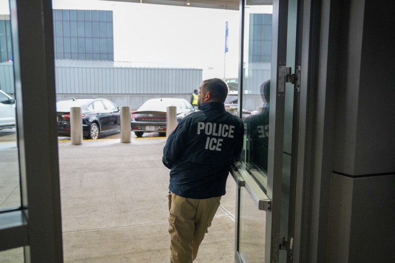 A U.S. Immigration and Customs Enforcement officer stands at John F. Kennedy International Airport.