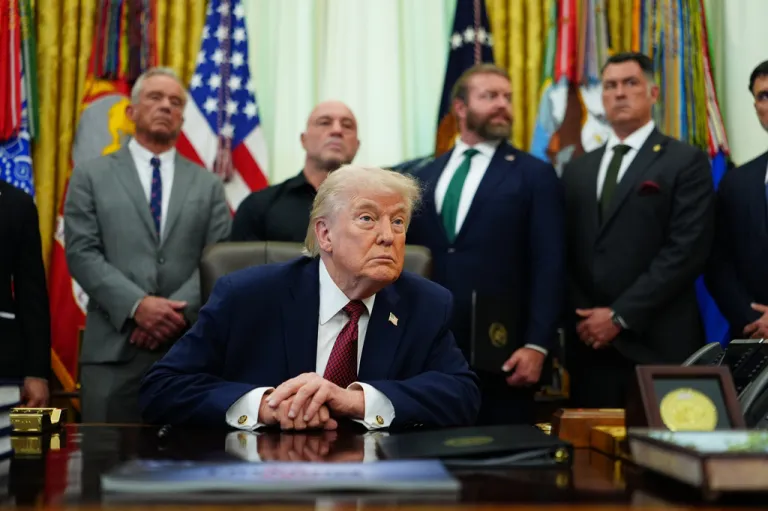 President Donald Trump listens to a reporter's question in the Oval Office of the White House.