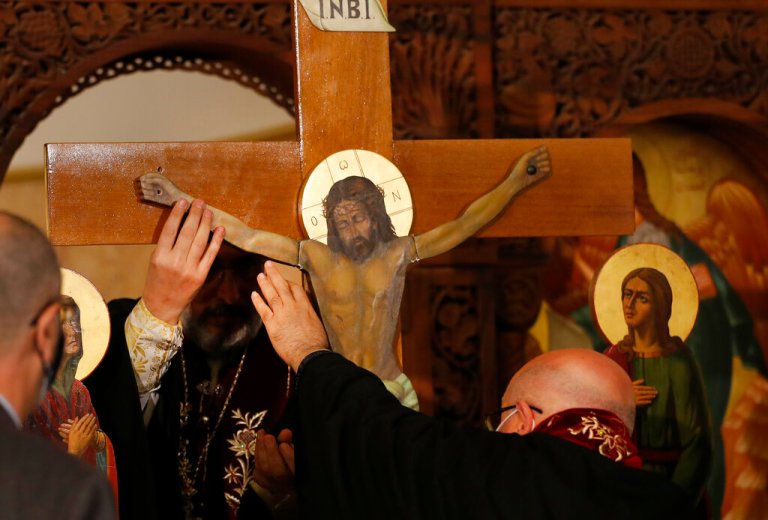 Priests take off a statue of Jesus from the Cross, during a Good Friday Mass for the Passion of Christ, at a church in Beirut, Lebanon, Friday, April 2, 2021. Christians in Lebanon observed Good Friday under a COVID-19 lockdown and amid a severe economic crisis exacerbated by the massive explosion that demolished parts of the capital last year. Even traditional Easter sweets are a luxury few can afford. (AP Photo/Hussein Malla)
