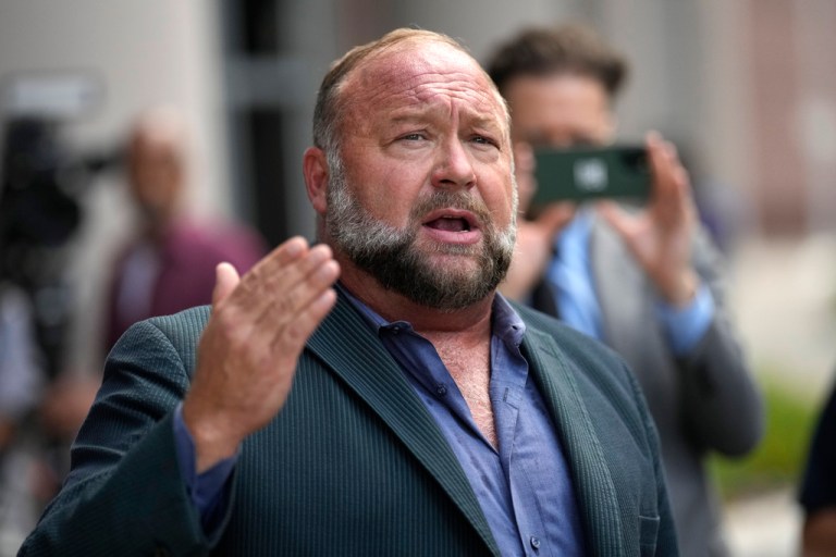 Alex Jones speaks to the media after arriving at the federal courthouse