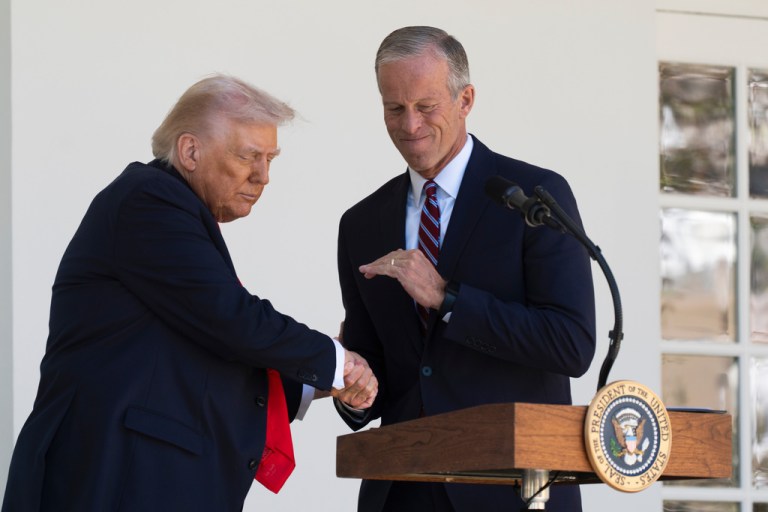 President Donald Trump shakes hands with Senate Majority Leader John Thune