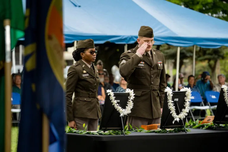 U.S. Army soldiers salute framed photos of former University of Hawaii ROTC cadets during a posthumous commissioning ceremony at Ke'ehi Lagoon Memorial Park.