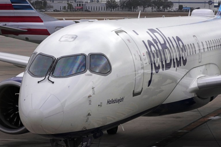 A Jet Blue Airlines jet pushes back from a gate at Pittsburgh International Airport .