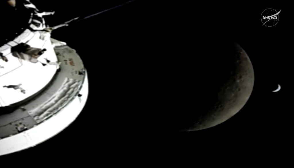 In this image from video provided by NASA, the Orion Spacecraft, the Earth, and the moon are seen from a camera as the Artemis II crew and spacecraft travel farther into Space.
