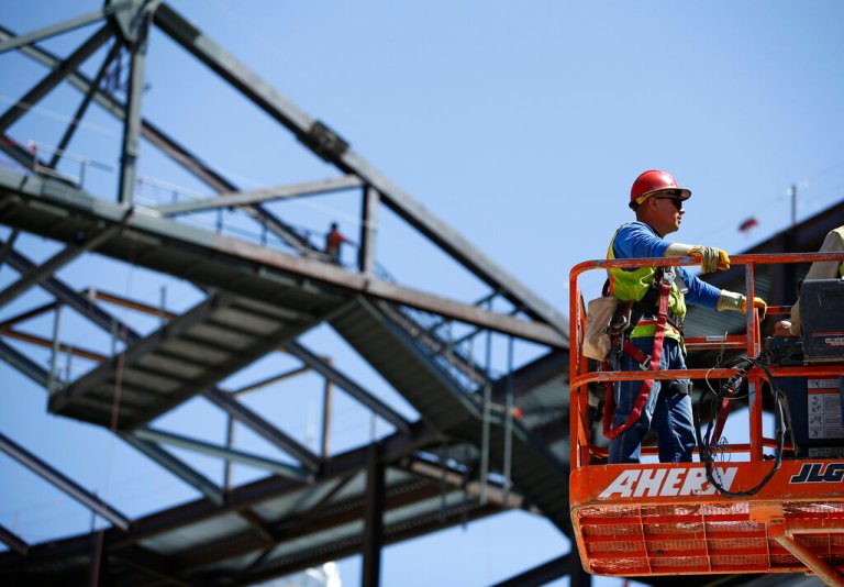 A worker rides a basket at an MGM arena being built behind the New York-New York casino-hotel on the Las Vegas Strip in 2015.