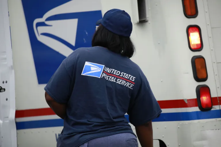 A United States Postal Service (USPS) worker outside a USPS distribution center in Chicago, Illinois, U.S., on Tuesday, Oct. 12, 2021. FedEx, UPS, Amazon.com and the U.S. Postal Service are busy hiring temporary and part-time workers ahead of the peak season, which will start to ramp up in November. Competition will be fierce for labor in and out of the parcel industry. Photographer: Luke Sharrett/Bloomberg via Getty Images