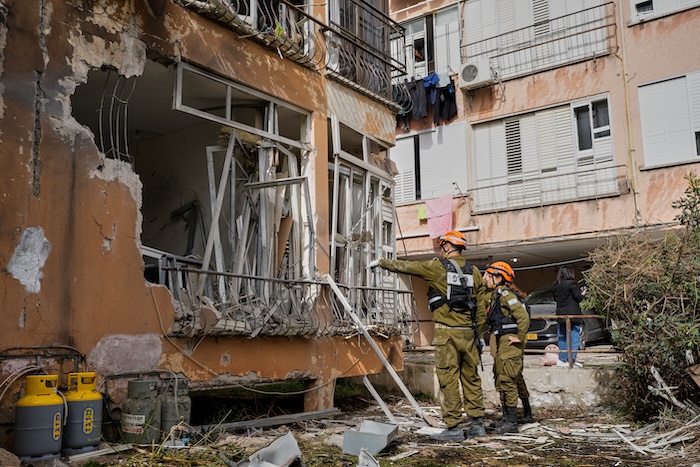 Israeli security forces inspect damage at an apartment building struck by an Iranian missile.