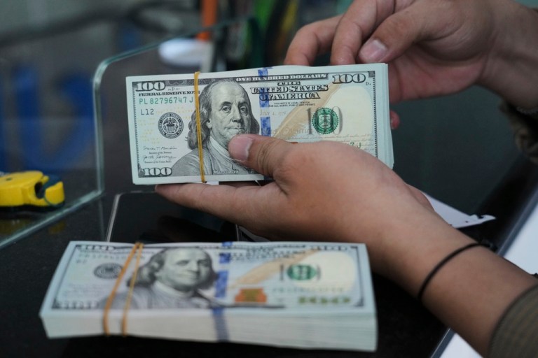 An employee counts U.S. dollar notes at a money changer in Jakarta, Indonesia.