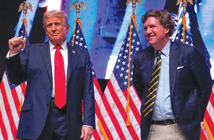 Then-Republican presidential nominee former President Donald Trump speaks with Tucker Carlson during an event on Oct. 31, 2024, in Glendale, Arizona. (Julia Demaree Nikhinson/AP)