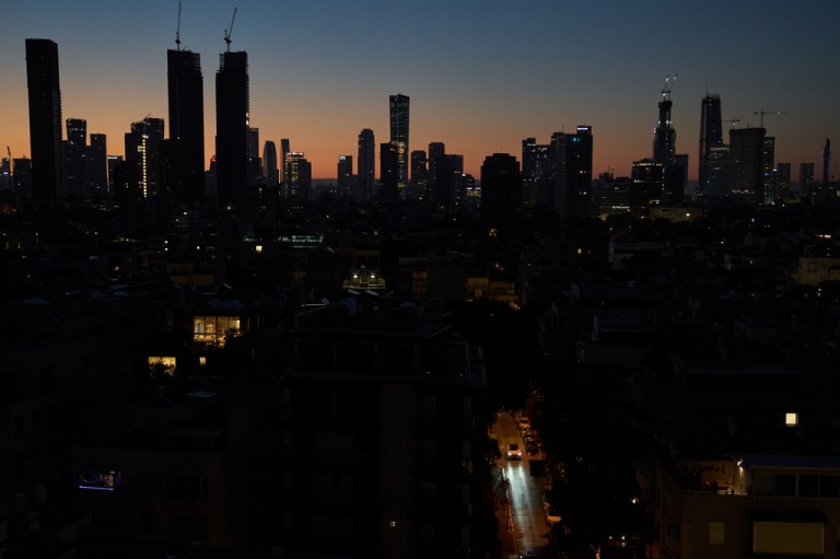 A car moves down a street in the early morning in Tel Aviv, Israel.